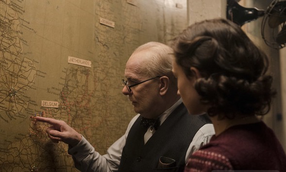 Churchill pointing at map with woman in foreground